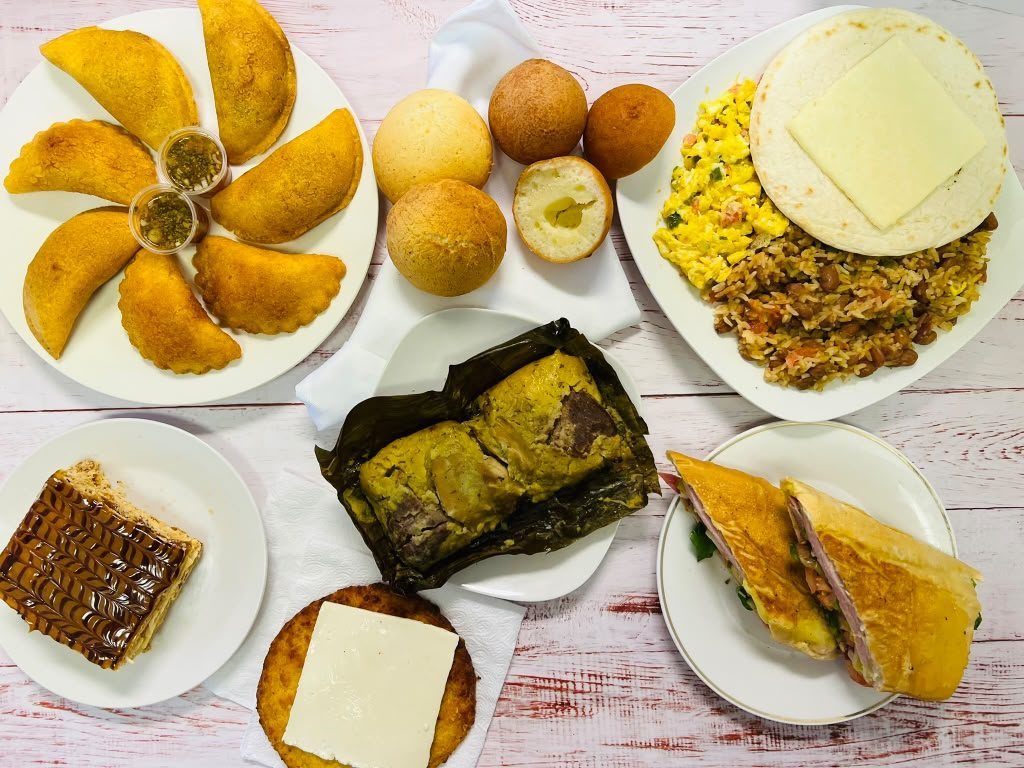 Mesa de La Semilla: empanadas, calentado, tamal y sándwich cubano